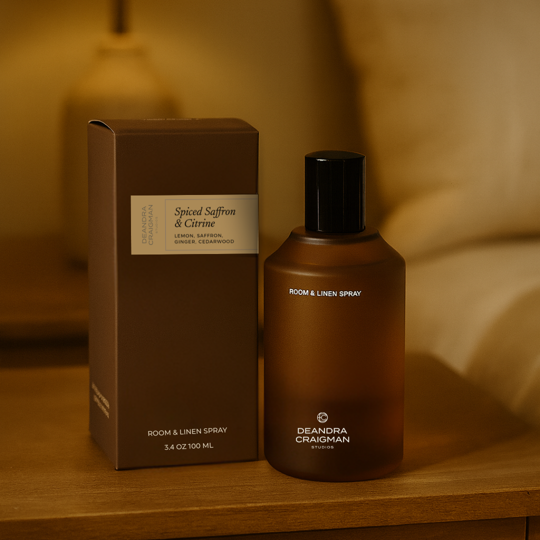 Room spray bottle and packaging on a wooden surface with warm lighting